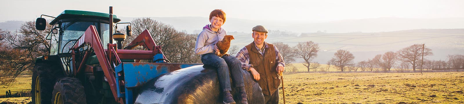 Father and son outdoors with a tractor.