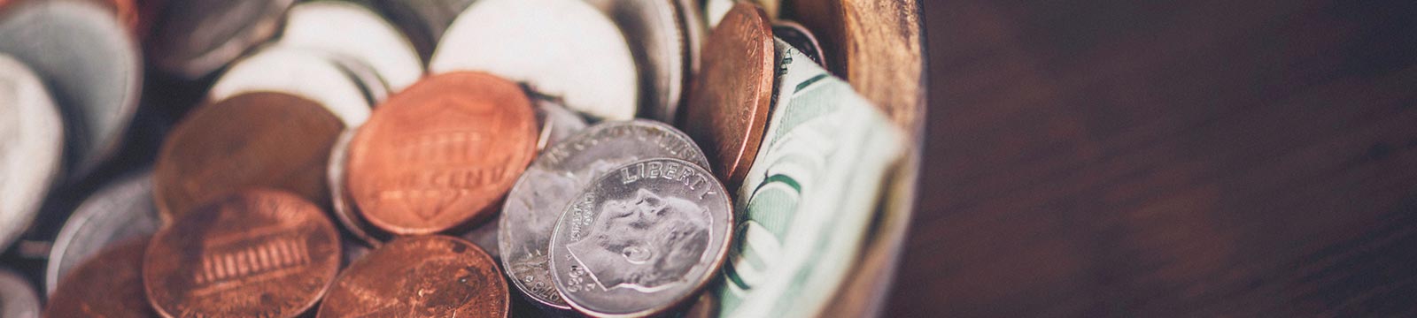 Coins and bills in a bowl.